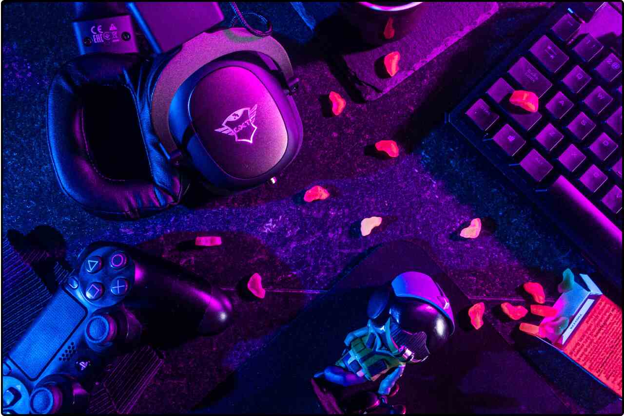 Flatlay view of various gaming equipment including controllers and headphones.